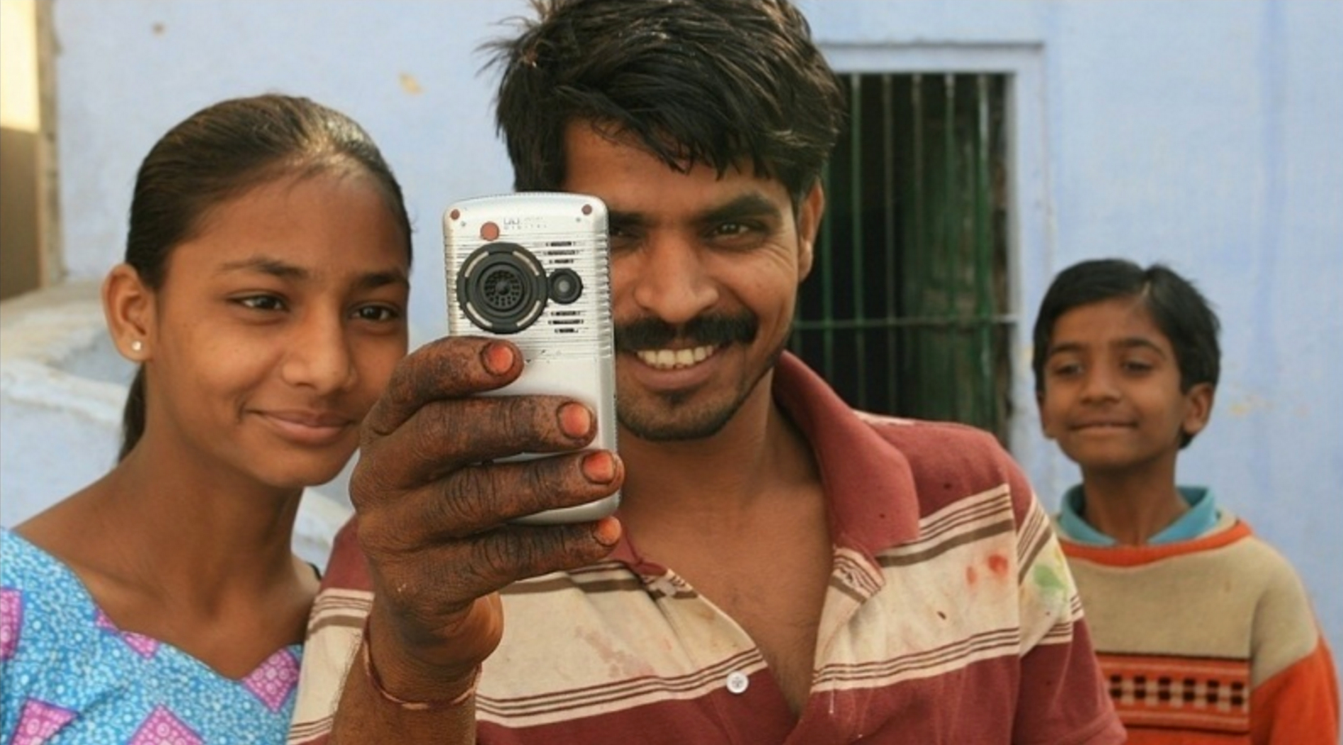 Man with daughters taking a video.