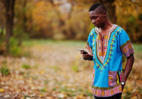 African man in africa traditional shirt on autumn park.