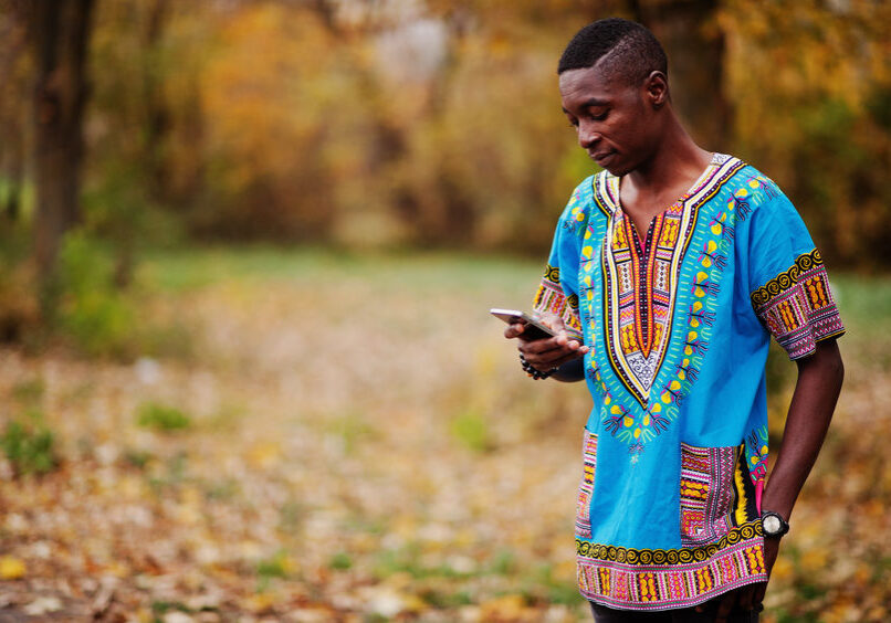 African man in africa traditional shirt on autumn park.