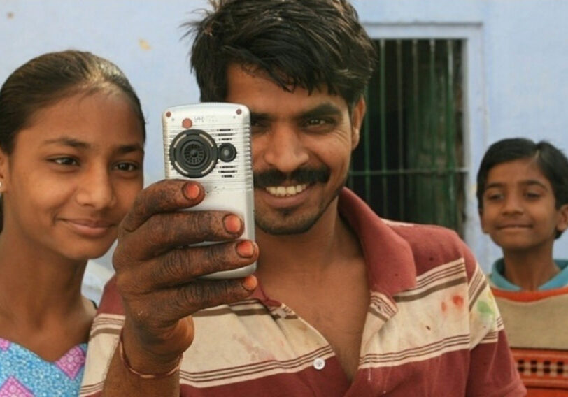 Man with daughters taking a video.